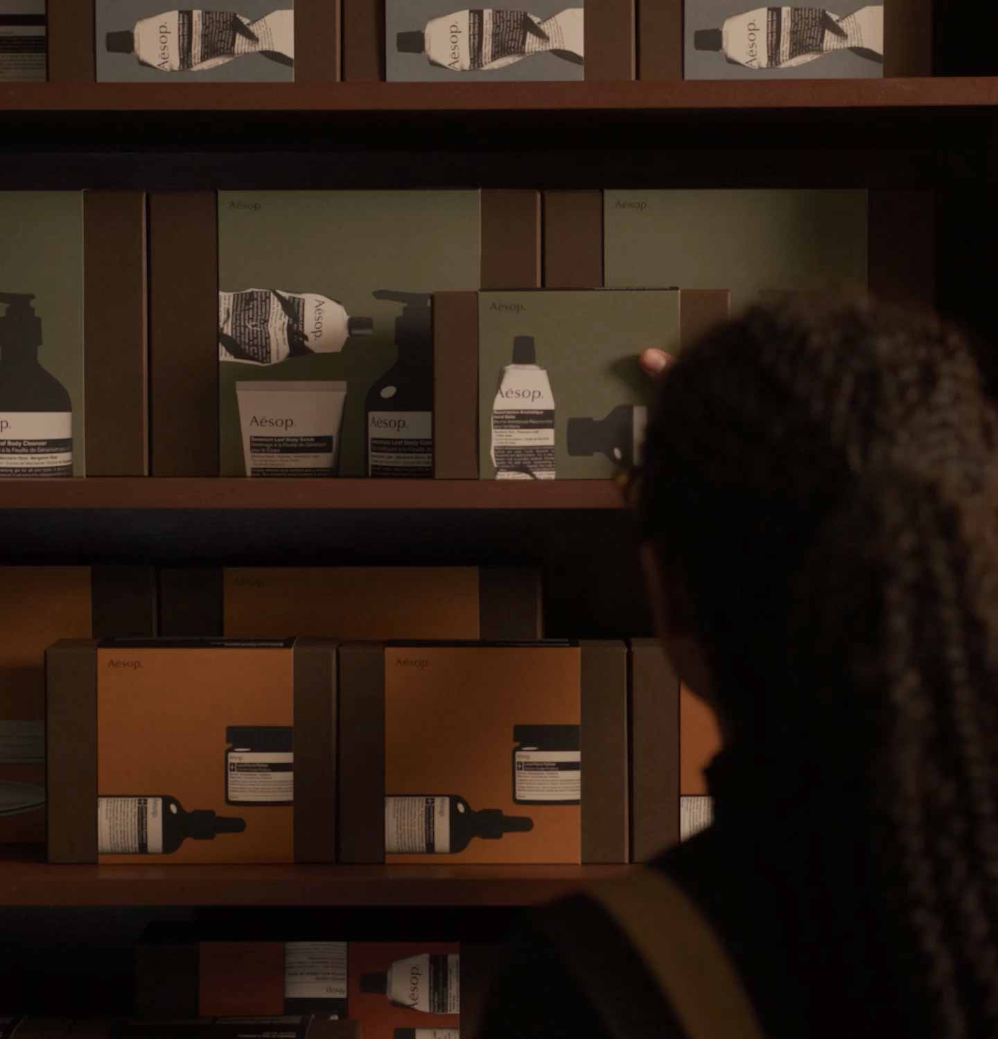 Aesop festive gift kits selection stacked on shelving display.