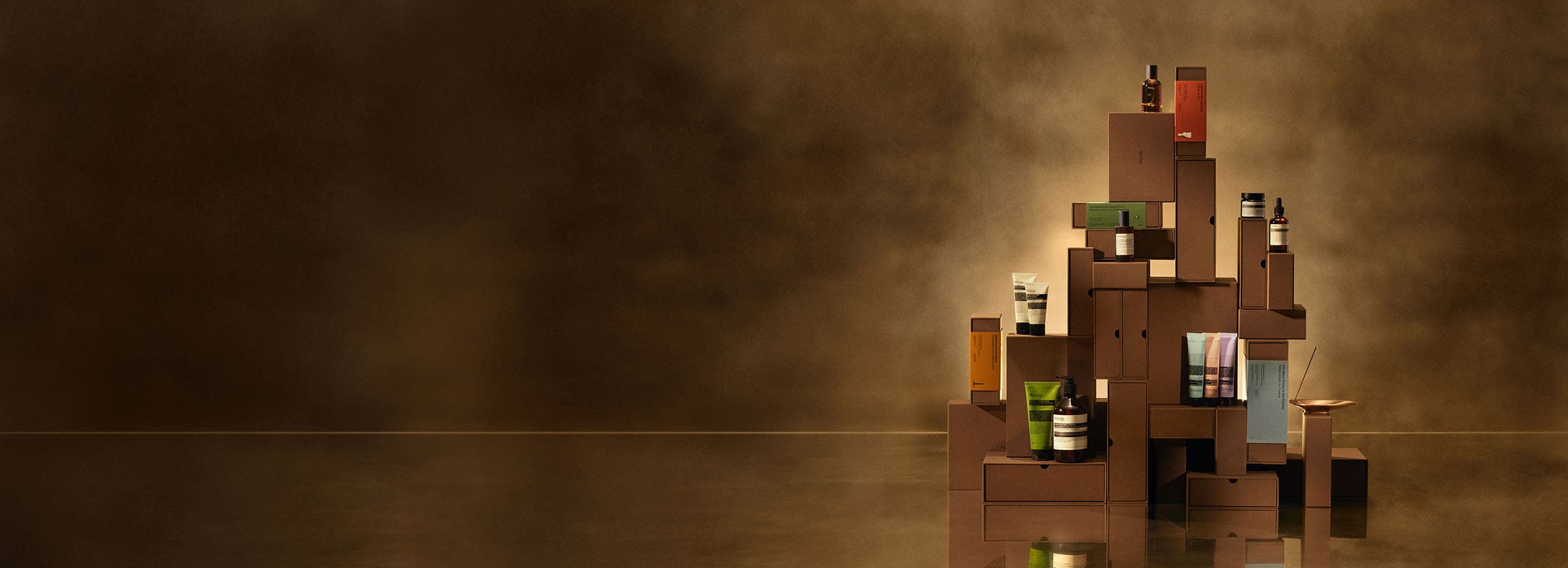 Aesop festive gift kits built into a tower on a brass countertop.