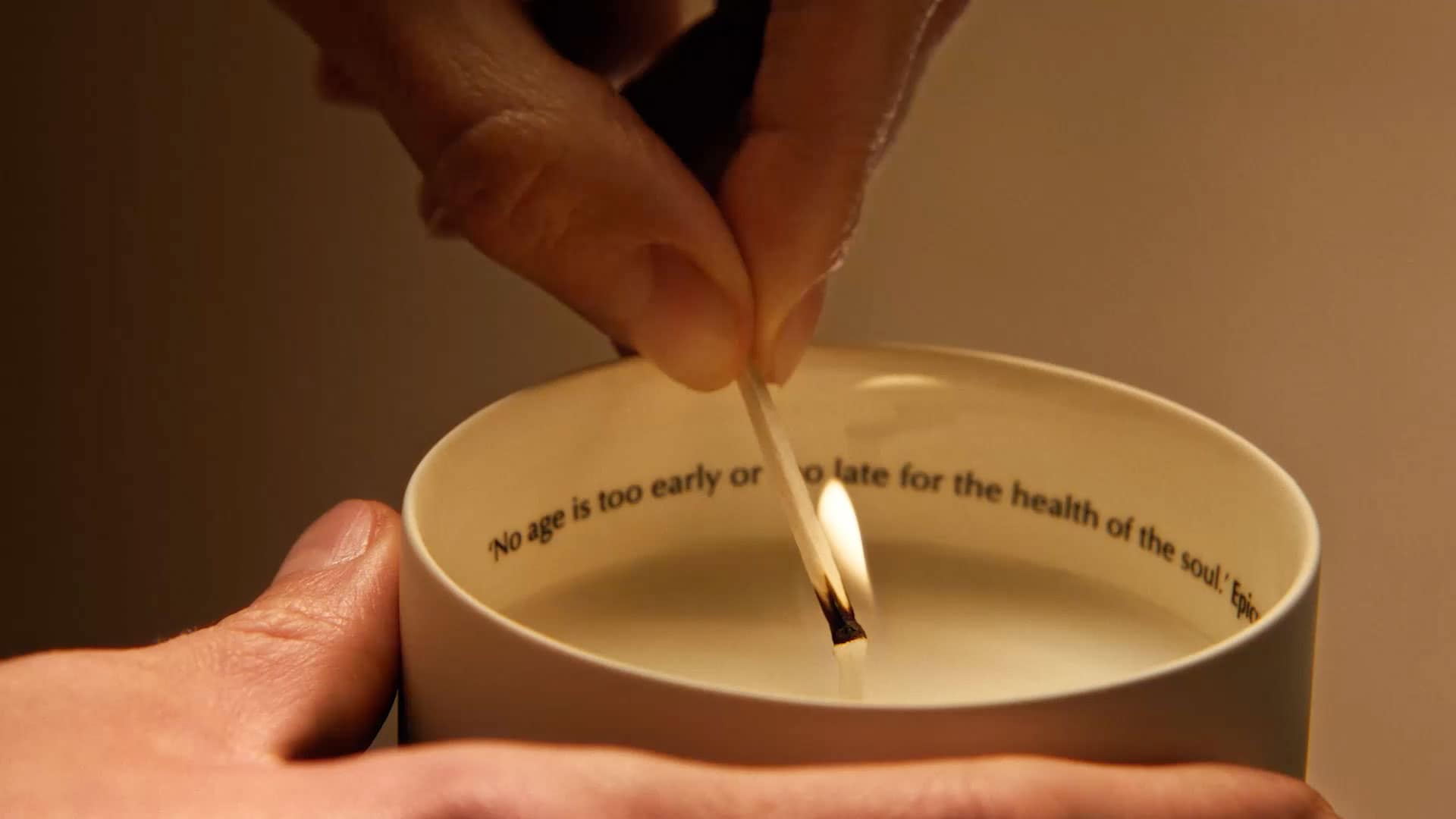 Aesop candle being lit by a match.