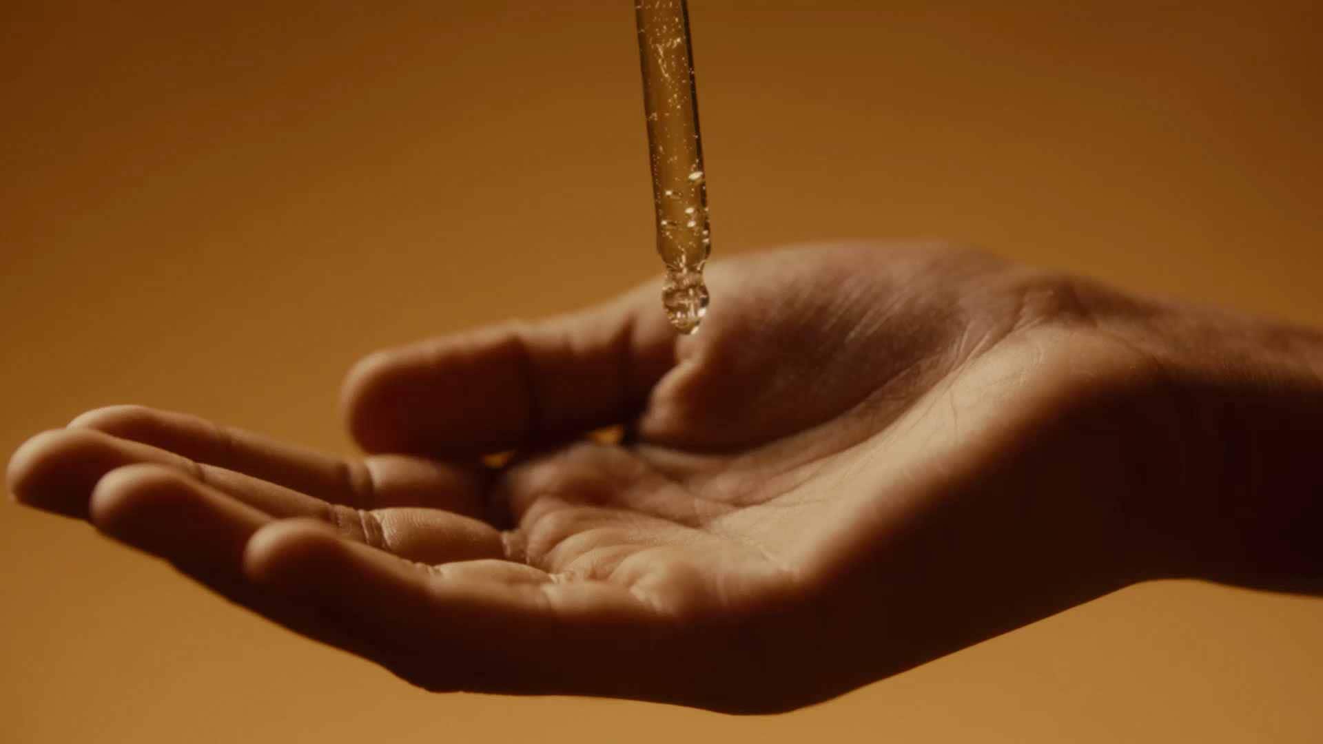 Un sérum transparent léger coule depuis la pipette dans le flacon.