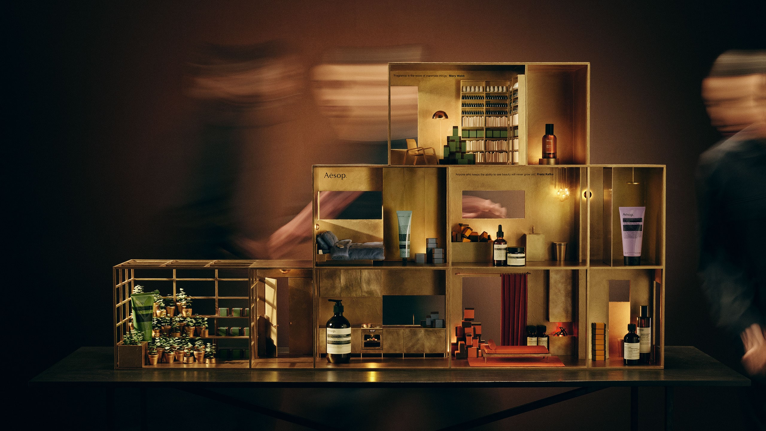 Festive miniature brass doll's house featuring a variety of Aesop products in every room.