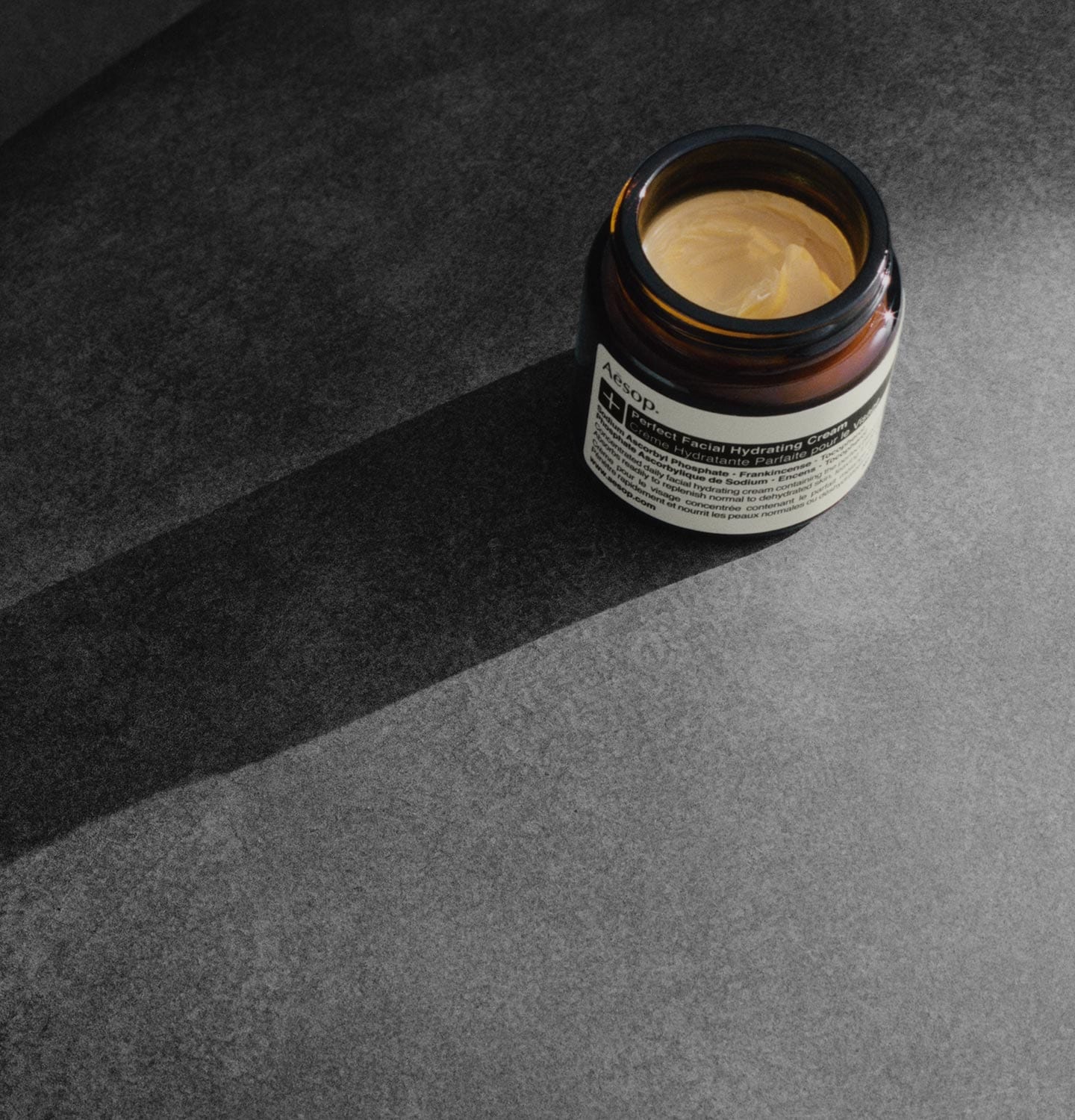 Un pot ouvert de la Crème Hydratante Parfaite pour le Visage révèle une crème lisse et onctueuse.