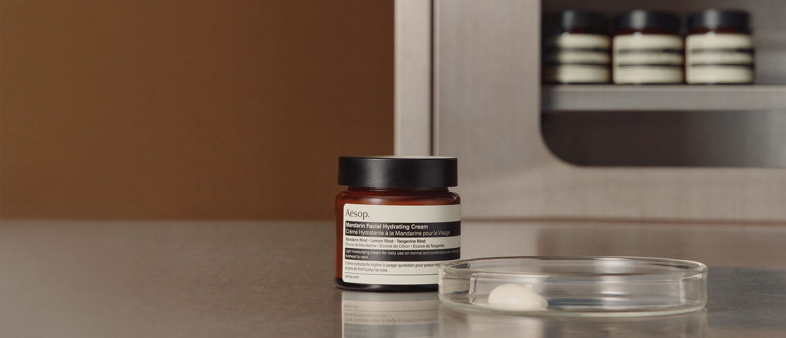 Mandarin Facial Hydrating Cream jar placed next to a petri dish