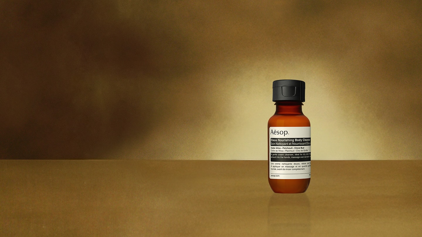 Eleos body cleanser 50mL bottle placed in front of brown background